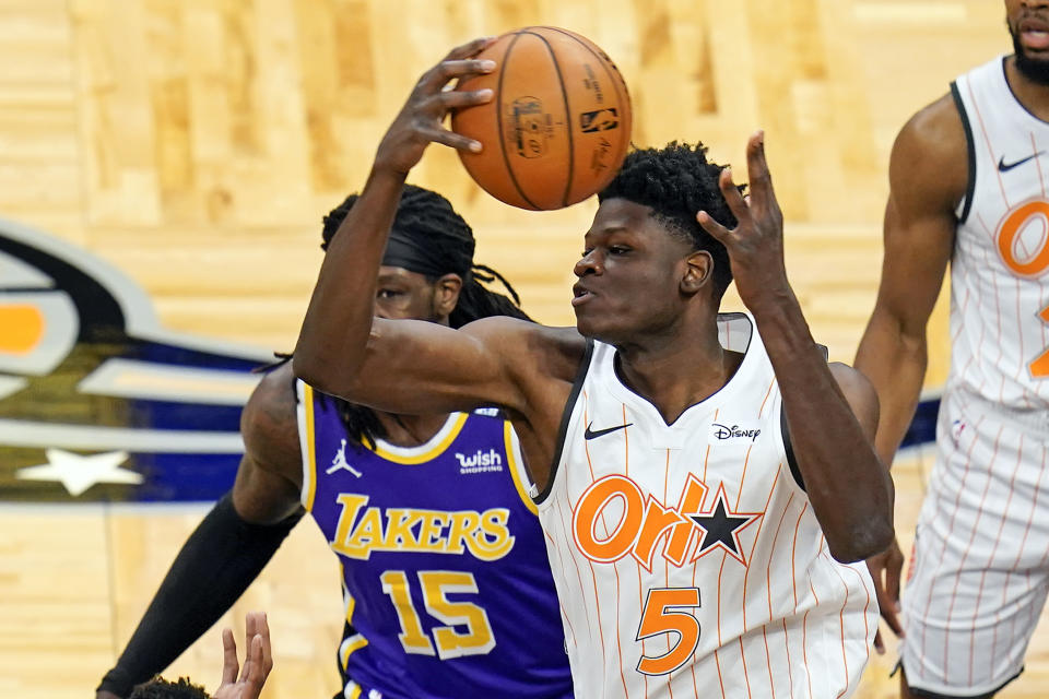 Orlando Magic center Mo Bamba (5) collects a rebound in front of Los Angeles Lakers center Montrezl Harrell (15) during the first half of an NBA basketball game, Monday, April 26, 2021, in Orlando, Fla. (AP Photo/John Raoux)