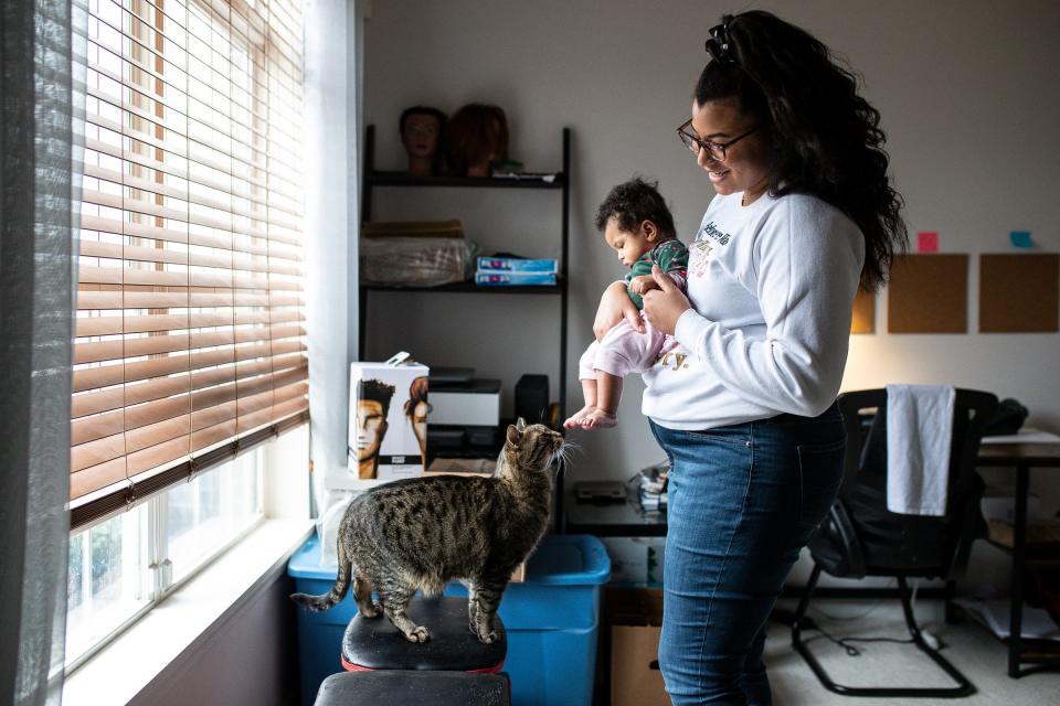 Lacey Jones and her 4-month-old daughter Mia Jones play with their cat Slim at home in Detroit on Friday, April 1, 2022.