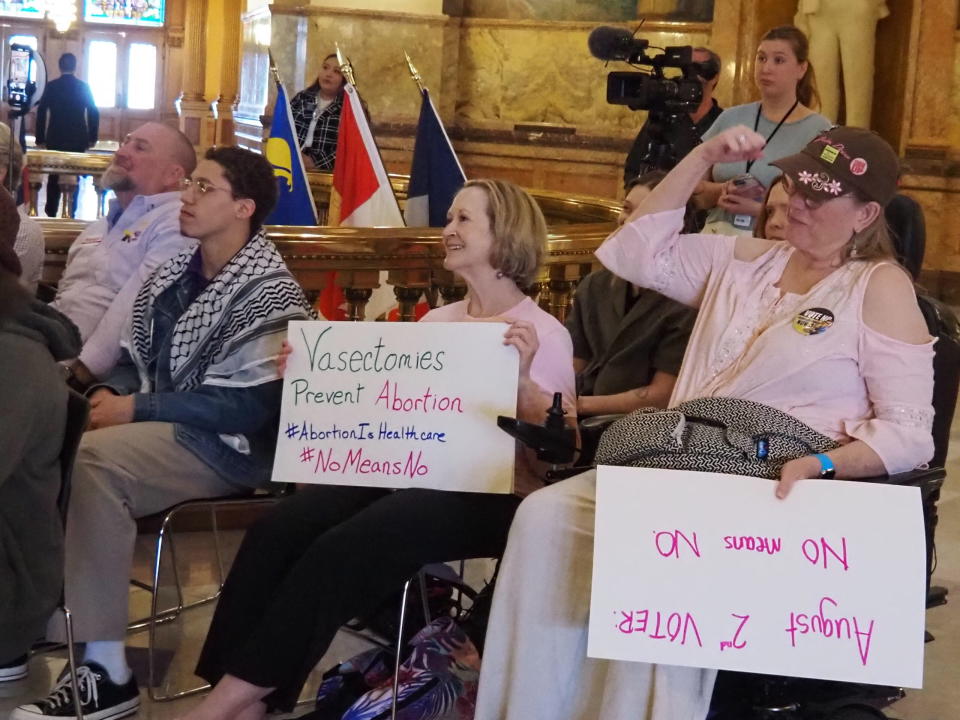 Reproductive rights advocates hold up signs during a Monday, April 29, 2024 rally in the Statehouse. (Rachel Mipro/Kansas Reflector)