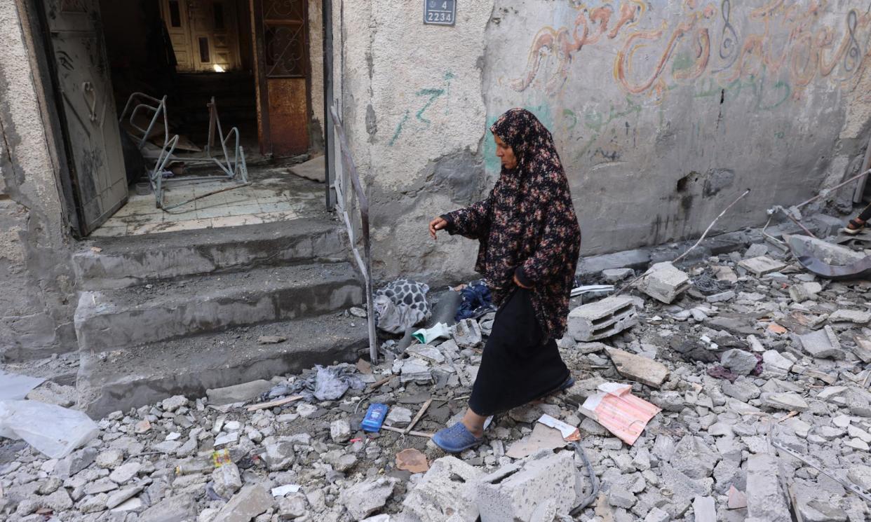 <span>A woman walks through a destroyed home that was struck during Israeli bombardment in Rafah's Tal al-Sultan district.</span><span>Photograph: AFP/Getty Images</span>