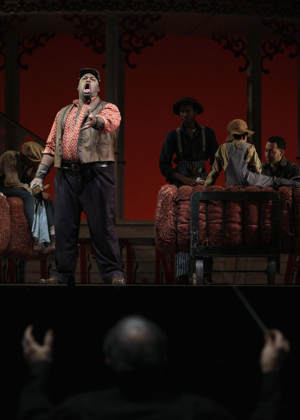 In this photo taken Feb. 9, 2012, Morris Robinson, left, portraying Joe, sings Ol' Man River at the direction of conductor John DeMain, foreground, at a dress rehearsal during the first act of the Lyric Opera of Chicago's production of "Show Boat." (AP Photo/M. Spencer Green)