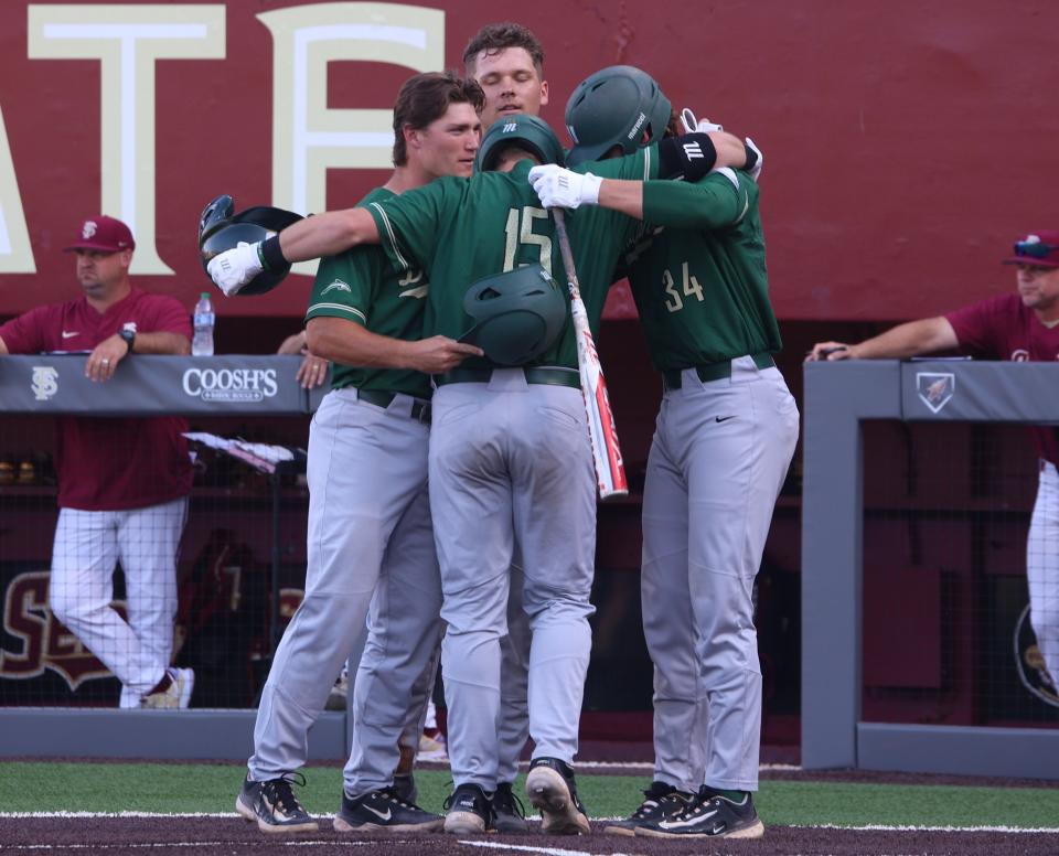 Jacksonville University players Colin Wetterau, Hogan McIntosh and Kris Armstrong greet Chandler Howard of Lake City after Howard's grand-slam home run in the first inning on Tuesday at Florida State.