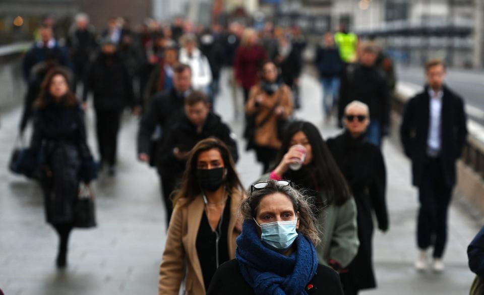Commuters walk over London Bridge station on the morning face masks became mandatory once more in England (EPA)