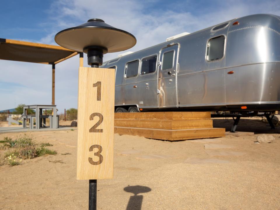 Airstream trailers outside at Autocamp's Joshua Tree location. There's tables and chairs between each trailer.