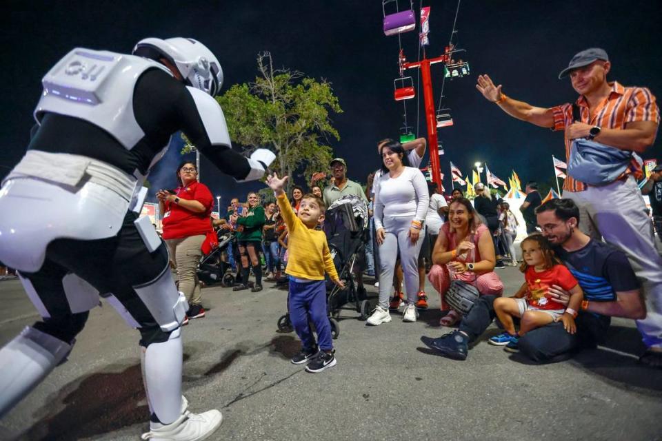 A Star Wars Stormtrooper high fives Felix Avila, 3, during a dance performance at the 2024 Miami-Dade County Youth Fair & Exposition. The theme of the 72nd edition is “Spaceventure,” held in Miami on Thursday, March 14, 2024.