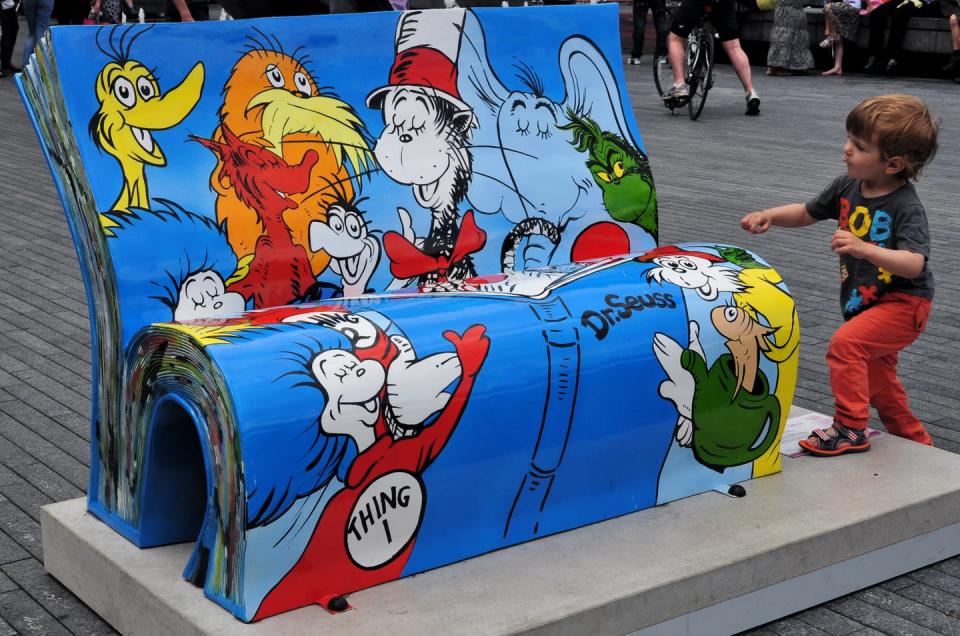 A child approaches a Dr. Seuss BookBench sculpture