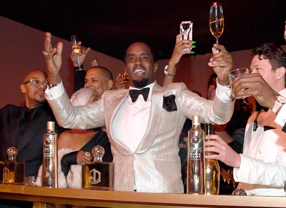 Sean Combs levanta uma taça em sua festa de aniversário de 50 anos.