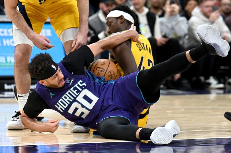 Charlotte Hornets guard Seth Curry, left, battles for control of a loose ball with Indiana Pacers forward Pascal Siakam, center, during second half action at Spectrum Center in Charlotte, NC on Monday, February 12, 2024. The Hornets defeated the Pacers 111-102.
