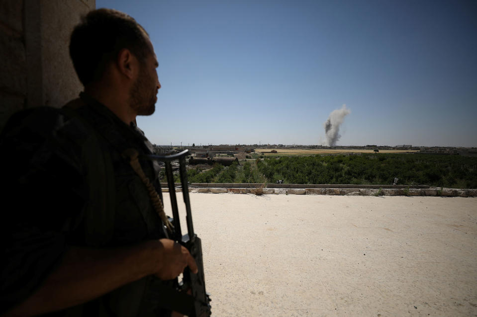 <p>A Syrian Democratic Forces (SDF) fighter takes a position as smoke rises from the al-Mishlab district at Raqqa’s southeastern outskirts, Syria June 7, 2017. (Photo: Rodi Said/Reuters) </p>