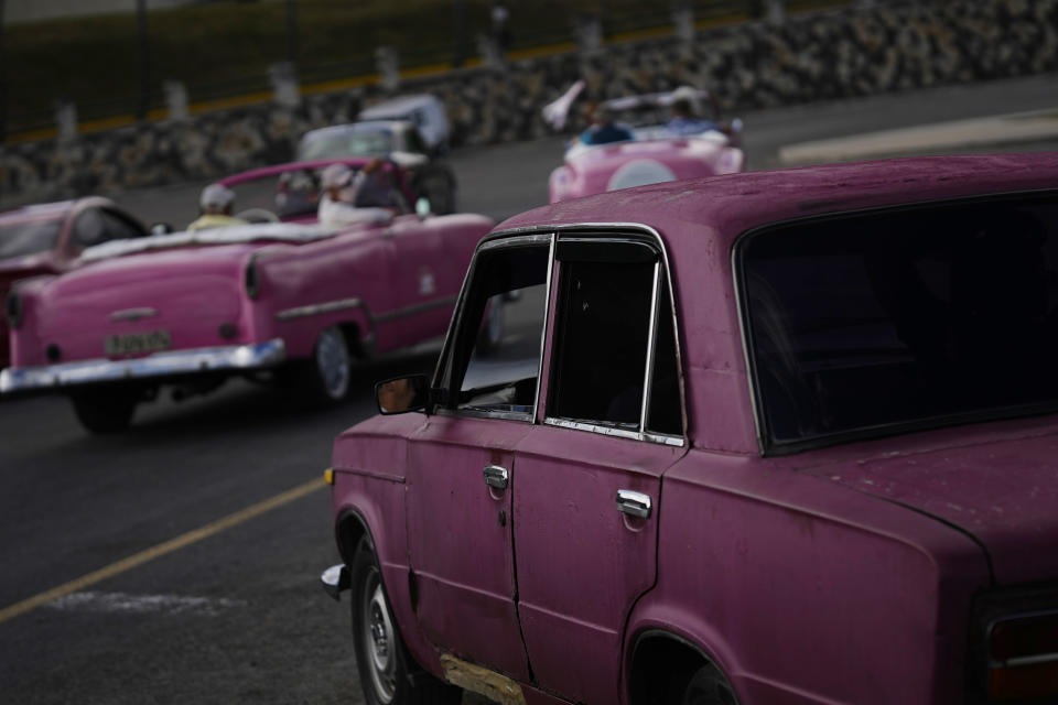 A vintage Russian-made Lada car, right, parks in Havana, Cuba, Friday, April 1, 2022. Global restrictions on transport and trade with Russia after its invasion of Ukraine pose a serious problem for Cubans because much of the island's fleets of trucks, buses, cars and tractors came from distant Russia and are now aging and in need of parts. (AP Photo/Ramon Espinosa)