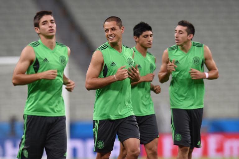 Mexico's forward Javier Hernandez warms up with teammates during a training session at the Castelao Stadium in Fortaleza on the eve of a FIFA World Cup match between Brazil and Mexico on June 16, 2014