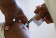 FILE - In this Feb. 17, 2021, file photo, a health care worker receives a Johnson & Johnson vaccine at a hospital in Khayelitsha, Cape Town, South Africa. South Africa has suspended giving the Johnson & Johnson vaccine as a "precautionary measure" following the FDA decision in the United States to pause the use of the vaccine while very rare blood clot cases are examined. (AP Photo/Nardus Engelbrecht)