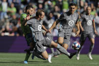 Minnesota United midfielder Kevin Molino, second from left, gets to a ball in front of Seattle Sounders forward Nicolas Lodeiro, left, during the first half of an MLS soccer match, Sunday, Oct. 6, 2019, in Seattle. The Sounders won 1-0. (AP Photo/Ted S. Warren)