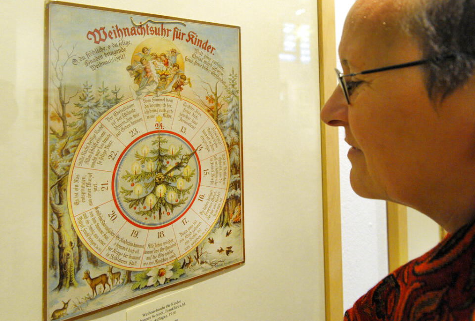 A visitor looks at a historical “Christmas clock for children” from 1910 at the exhibition “100 years Advent Calendars” at the museum for town history in Leipzig, eastern Germany, on Nov. 24, 2008. (AP Photo/Eckehard Schulz)