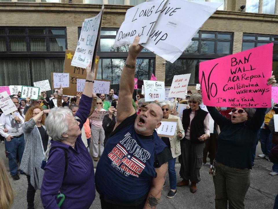 David Edwards Sr. of Burlington, Ky., right, shows his support for President Trump at a rally protesting the appearance of Kentucky Sen. Mitch McConnell at the meeting of the Northern Kentucky Chamber of Commerce, Thursday, Feb. 23, 2017, in Covington, Ky. (AP Photo/Timothy D. Easley)