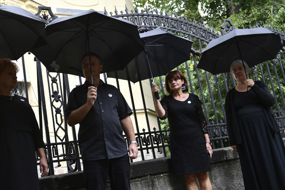FILE - Members of Hungary's Teachers' Union (PSZ) stand during a protest, at a school year opening event, with black umbrellas over their heads to signify the problems of education, in Budapest, Hungary, Thursday, Sept. 1, 2022. Public schools in Poland and Hungary are facing a shortage of teachers at a time when both countries are taking in many Ukrainian refugee children. For years, teachers have been fleeing public schools over grievances regarding low wages and a sense of not being valued by their governments. (AP Photo/Anna Szilagyi, File)