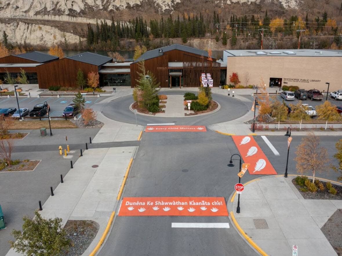 Teagyn Vallevand, the artist behind the orange-and-white crosswalks, said language was important everyone involved. That's why two out of the three crosswalks proclaim 'Every Child Matters' in English and Southern Tutchone. (Submitted by the City of Whtiehorse/Northern Drone Services - image credit)