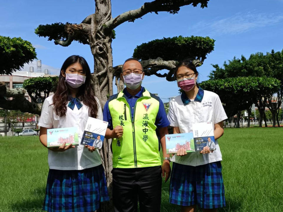 蔡玟翎（左）、施晴芃（右）會考寫作獲得六級分，校長張添唐致贈書籍及學校紀念筆記本給二人（記者施春瑛攝）