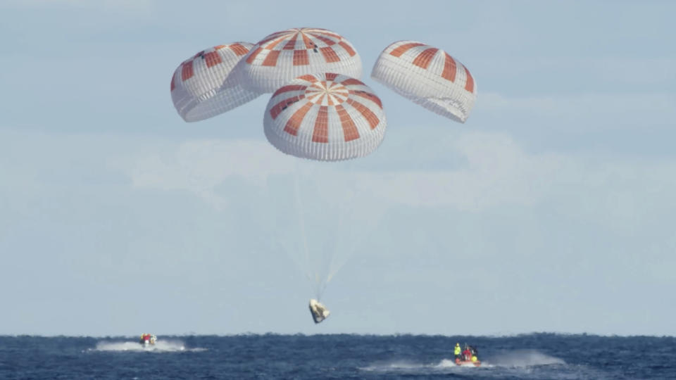 In this Friday, March 8, 2019 image from video made available by SpaceX, the company's Crew Dragon descends to the Atlantic Ocean for a splashdown after a deorbit burn to reenter Earth's atmosphere, returning from the International Space Station. (SpaceX via AP)