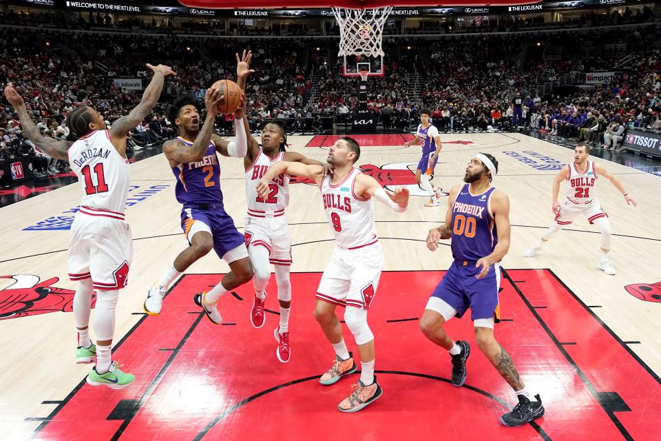 Phoenix Suns' Elfrid Payton (2) shoots between Chicago Bulls' DeMar DeRozan (11) and Ayo Dosunmu during the first half of an NBA basketball game Monday, Feb. 7, 2022, in Chicago. (AP Photo/Charles Rex Arbogast)