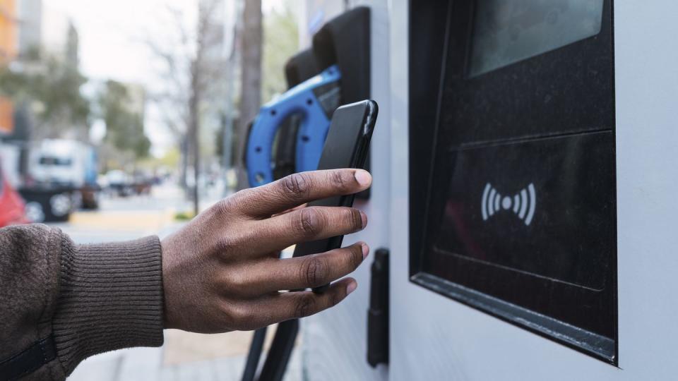 hand of man paying through smart phone at charging station