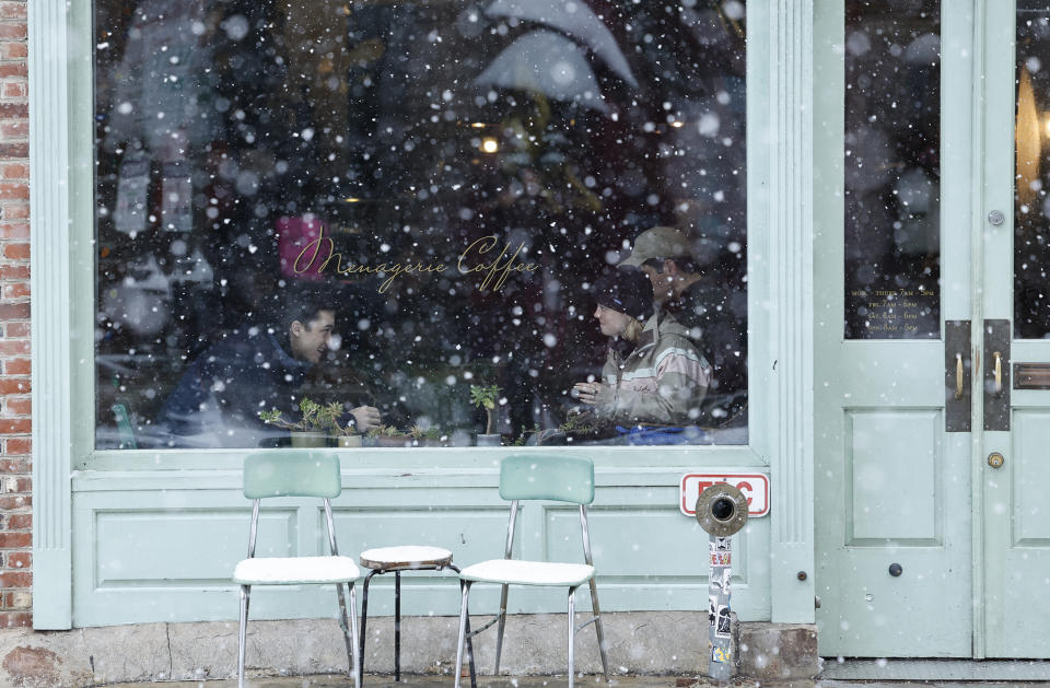 Clientes en el interior de una cafetería mientras nieva en el vecindario de Old City, en Filadelfia, el 19 de enero de 2024. (Yong Kim/The Philadelphia Inquirer vía AP)