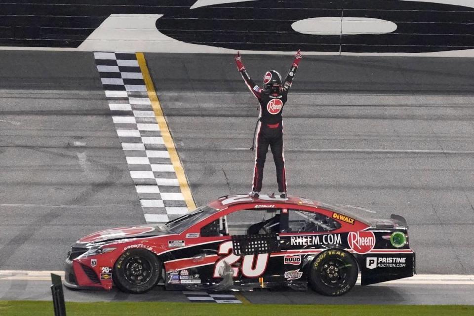 Christopher Bell stands on his car and celebrates in front of the grandstands after winning the NASCAR Cup Series road course auto race at Daytona International Speedway, Sunday, Feb. 21, 2021, in Daytona Beach, Fla. (AP Photo/John Raoux)