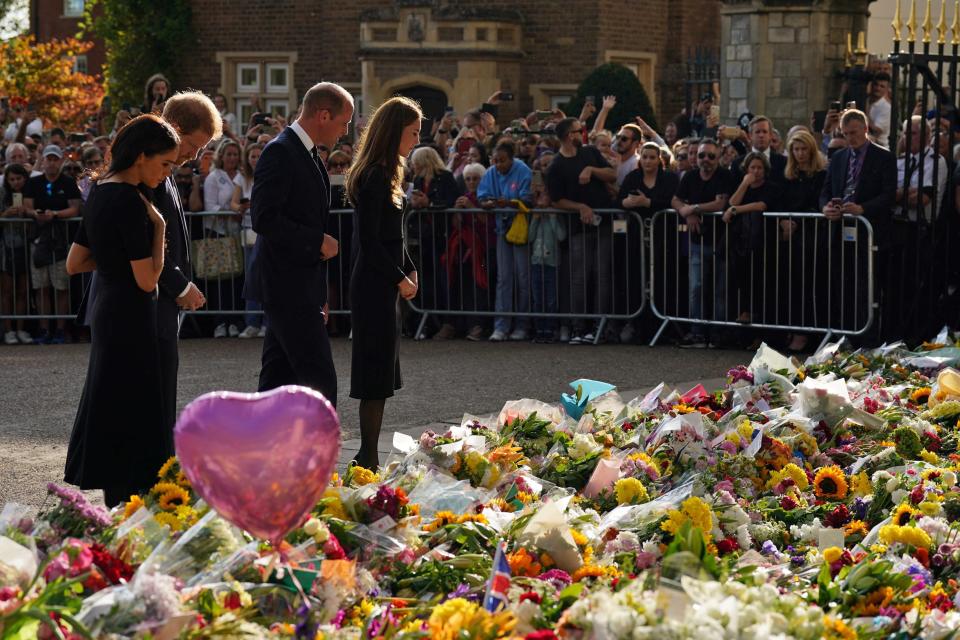 <p>From left: Meghan, Duchess of Sussex; Prince Harry, Duke of Sussex; Prince William, Prince of Wales; and Catherine, Princess of Wales look at floral tributes laid by members of the public on their walkabout at Windsor Castle on Sept. 10, 2022 before meeting well-wishers. (Photo by Kirsty O'Connor/Pool/AFP via Getty Images)</p> 