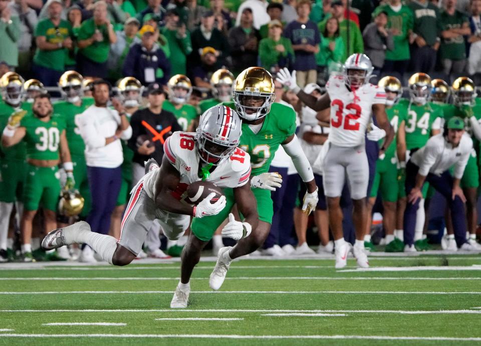 Sep 23, 2023; South Bend, Indiana, USA; Ohio State Buckeyes wide receiver Marvin Harrison Jr. (18) makes a catch against Notre Dame Fighting Irish safety Thomas Harper (13) on the last drive of the game during the fourth quarter of their game at Notre Dame Stadium.