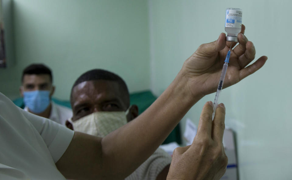 Eusebio Torres espera ser vacunado mientras una enfermera prepara la dosis de la vacuna cubana Abdala para el COVID-19 en el hospital Gustavo Aldereguia de Cienfuegos, Cuba, el domingo 30 de mayo de 2021. (AP Foto/Ismael Francisco)