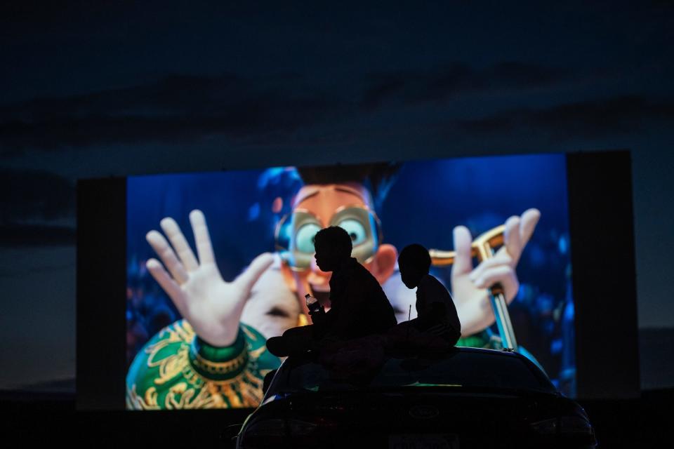 Children sit on top of a vehicle while watching "Despicable Me 4" at the Ford-Wyoming Drive-In in Dearborn on Tuesday, July 16, 2024.