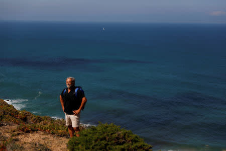 Miguel Lacerda, 62, rests as he goes down a cliff to collect trash at a beach at the coast near Sintra, Portugal May 22, 2019. Picture taken May 22, 2019. REUTERS/Rafael Marchante