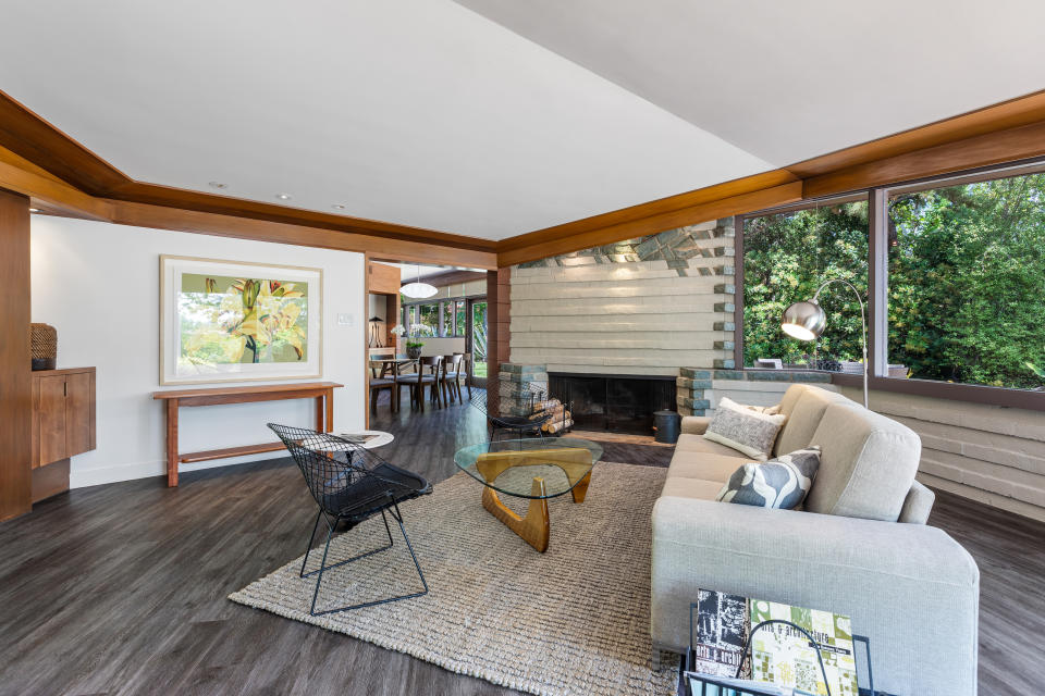 A living room with a fireplace and mid-century style furniture