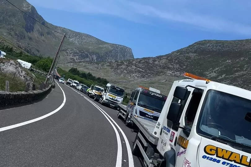 Vehicle recovery trucks line up to tow away cars parked illegally on the A5 in the Ogwen Valley