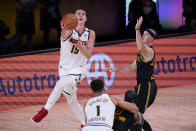 Denver Nuggets' Nikola Jokic (15) drives to the basket around Los Angeles Lakers' Alex Caruso, right, during the second half of an NBA conference final playoff basketball game Sunday, Sept. 20, 2020, in Lake Buena Vista, Fla. (AP Photo/Mark J. Terrill)