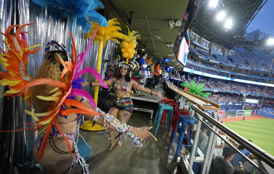 Carnival dancers perform during a break at a baseball game at Rogers Center in Toronto, Canada, Wednesday, July 27, 2022. The 55th annual parade returned to the streets after the COVID-19 pandemic cancelled it for two years in a row. (AP Photo/Kamran Jebreili)