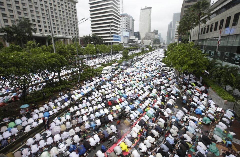 In this Friday, Dec. 2, 2016 file photo, Muslims attend Friday prayer during a rally against Jakarta's minority Christian Governor Basuki "Ahok" Tjahaja Purnama who is being prosecuted for blasphemy, at the main business district in Jakarta, Indonesia. Ahok, the first ethnic Chinese governor of Jakarta and the first Christian in more than half a century, had seemed unassailably popular until the accusation of blasphemy, a criminal offense in Indonesia, surfaced in September. Protests against him in November and December, organized by hard-line Islamic groups, drew hundreds of thousands to Jakarta's streets and shook the centrist-minded government of President Joko "Jokowi" Widodo. (AP Photo/Achmad Ibrahim, File)