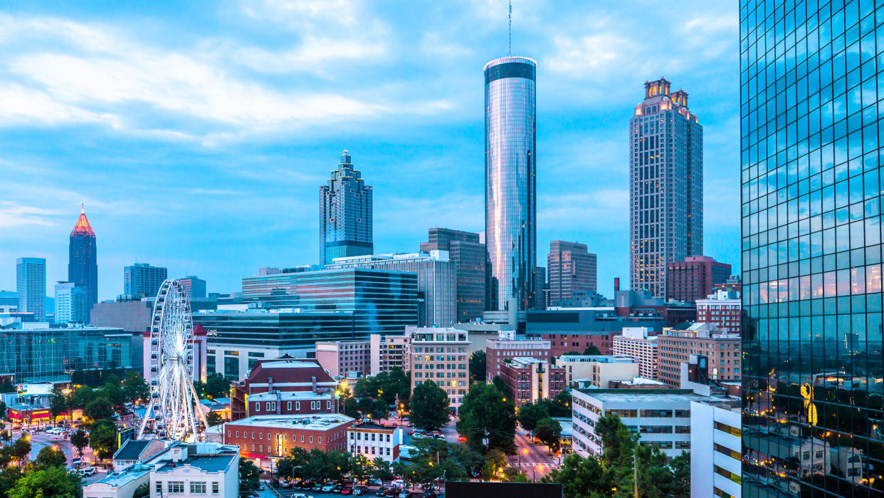 Skyline view of Downtown and Midtown Atlanta with ferris wheel from a rooftop bar and lounge.