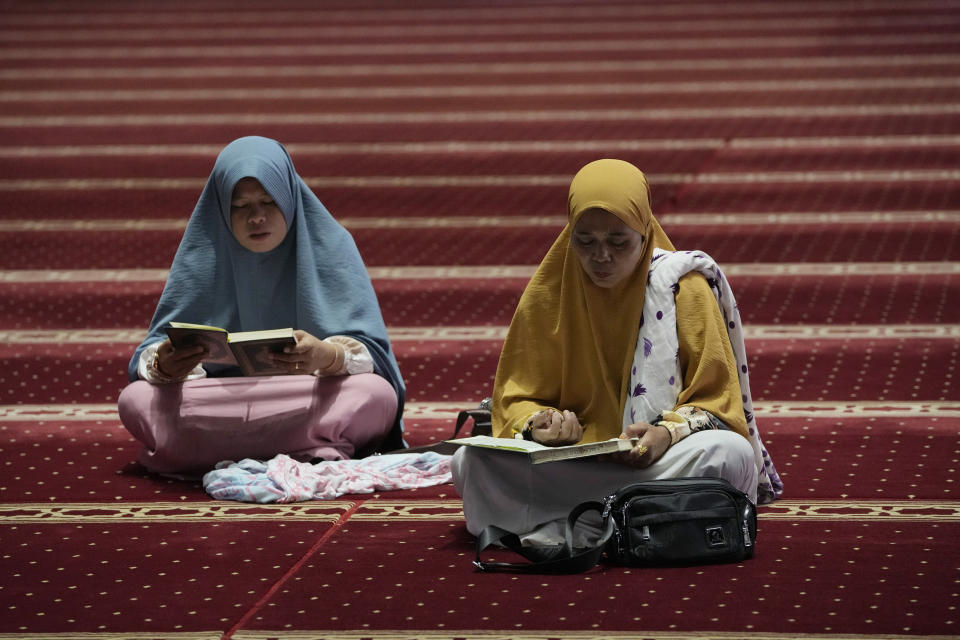 Mujeres musulmanas leen el Corán mientras esperan a la hora de romper el ayuno en el primer día del Ramadán en la mezquita Istiqlal en Yakarta, Indonesia, el martes 12 de marzo de 2024. (AP Foto/Achmad Ibrahim)