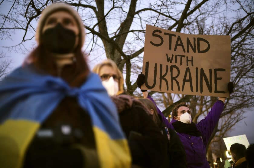 A man holds a poster in support of Ukraine as he attends a demonstration near the Russian embassy to protest against the escalation of the tension between Russia and Ukraine in Berlin, Germany, Tuesday, Feb. 22, 2022. Lawmakers gave Russian President Vladimir Putin permission to use military force outside the country on Tuesday. The move that could presage a broader attack on Ukraine after the U.S. said an invasion was already underway there. (AP Photo/Markus Schreiber)