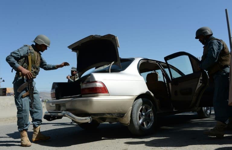 Afghan policemen search a vehicle in the city of Jalalabad, close to the border with Pakistan, on April 29, 2016, after a reported kidnapping of an Australian aid worker Kerry Jane Wilson