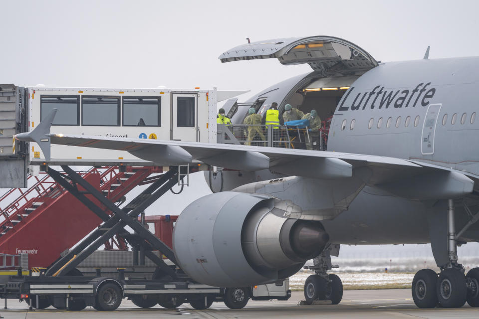 A Bundeswehr aircraft stands with its side flap open at the airport in Memmingen, Germany, Friday, Nov. 26, 2021. The German air force Luftwaffe will begin assisting the transfer of intensive care patients from hospitals in Bavaria to northern German states. (Peter Kneffel/dpa via AP)