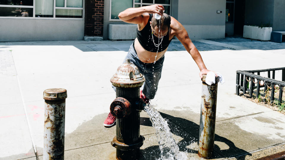 A pedestrian cools off at a hydrant during a heatwave in the East Village, New York, in June.