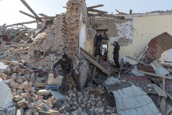 Locals clean up debris from the cultural centre destroyed in shelling earlier this month, as Russia&#39;s invasion of Ukraine continues, in the village of Byshiv outside Kyiv, Ukraine, March 24, 2022. REUTERS/Marko Djurica