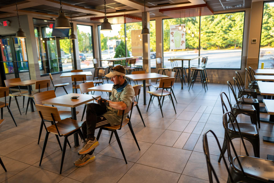 HACKETTSTOWN, NEW JERSEY - SEPTEMBER 02: Isaiah Shields pauses to check his location in a Burger King as he walks across America towards his destination in Maine on September 02, 2022 in Hackettstown, New Jersey. Isaiah, who left a career in finance, will have walked for nearly two years and over 3000 miles when he concludes his journey. The 29 year old from Utah, started his walk by traveling West to Seattle and then down to Texas and Florida before making his way up the East Coast towards Maine. Isaiah walks an average 20 plus miles a day and camps along the roadside or accepts offers for stays at local homes. He is documenting his trip on Facebook and thinks he will walk back home to Utah from Maine after a rest. Along the way he documents the cities and towns he passes through and enjoys the encounters he has with inquisitive locals. (Photo by Spencer Platt/Getty Images)