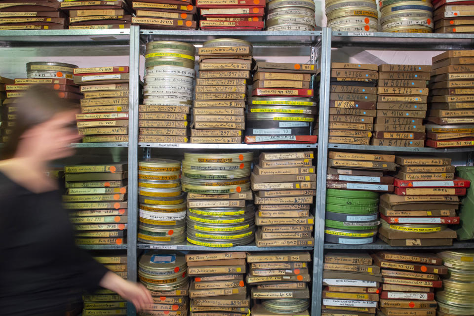 In this Wednesday, June 17, 2020 photo, film boxes and reels are stacked in the archive of PROGRESS Film, in Leipzig, Germany. A new project is underway to digitize thousands of East German newsreels, documentaries and feature films 30 years after Germany’s reunification. The movies that are being scanned, transcribed and posted online provide a look inside a country that no longer exists but was a critical part of the Cold War. (AP Photo/Jens Meyer)