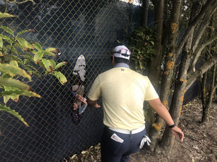 Joohyung Kim hands a signed golf ball through the fence by the No. 12 tee box to 3-year-old Quinn Gleason.