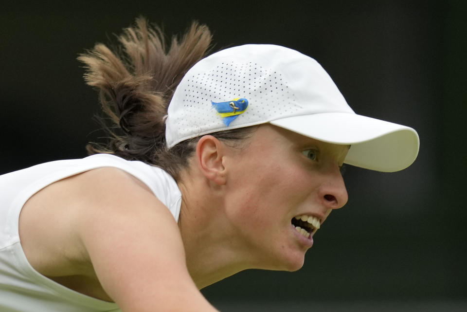 Poland's Iga Swiatek serves to Ukraine's Elina Svitolina in a women's singles match on day nine of the Wimbledon tennis championships in London, Tuesday, July 11, 2023. (AP Photo/Kirsty Wigglesworth)