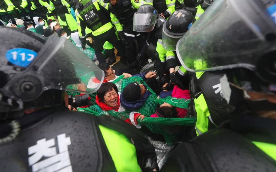 Riot police remove South Korean protesters blocking the road to oppose the deployment of the US Terminal High Altitude Area Defense (THAAD) system - YONHAP/AFP/Getty Images