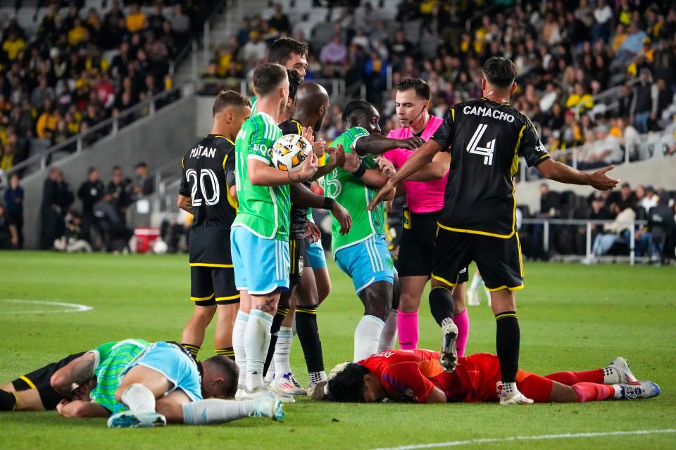 Sounders forward Jordan Morris, Crew midfielder Sean Zawadzki and goalie Abraham Romero lie on the ground after colliding in the first half on Saturday.